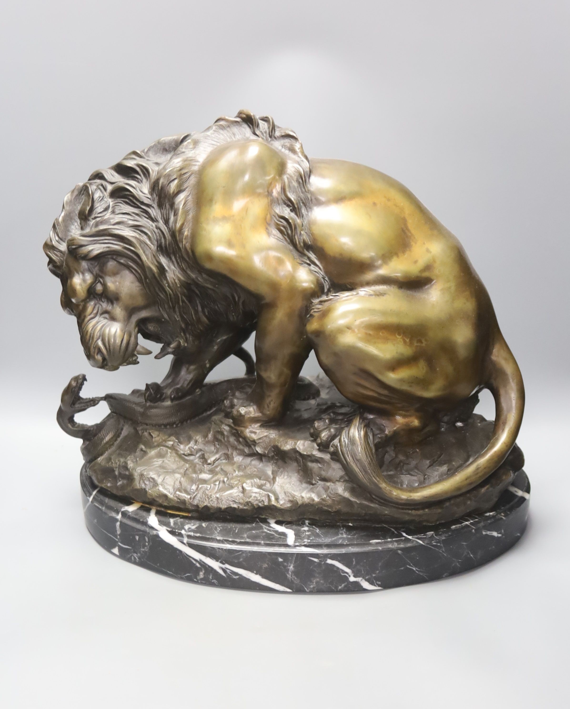 After Antoine-Louis Barye. A reproduction bronze of a tiger attacking a serpent, on a marble plinth, overall height 35cm